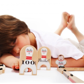 Enfant qui joue au mini jeu de bowling Les Jouets Libres