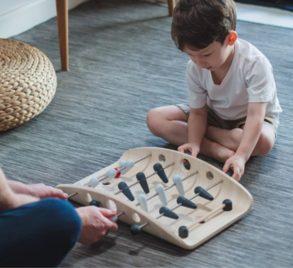 Enfant qui joue au babyfoot de plantoys